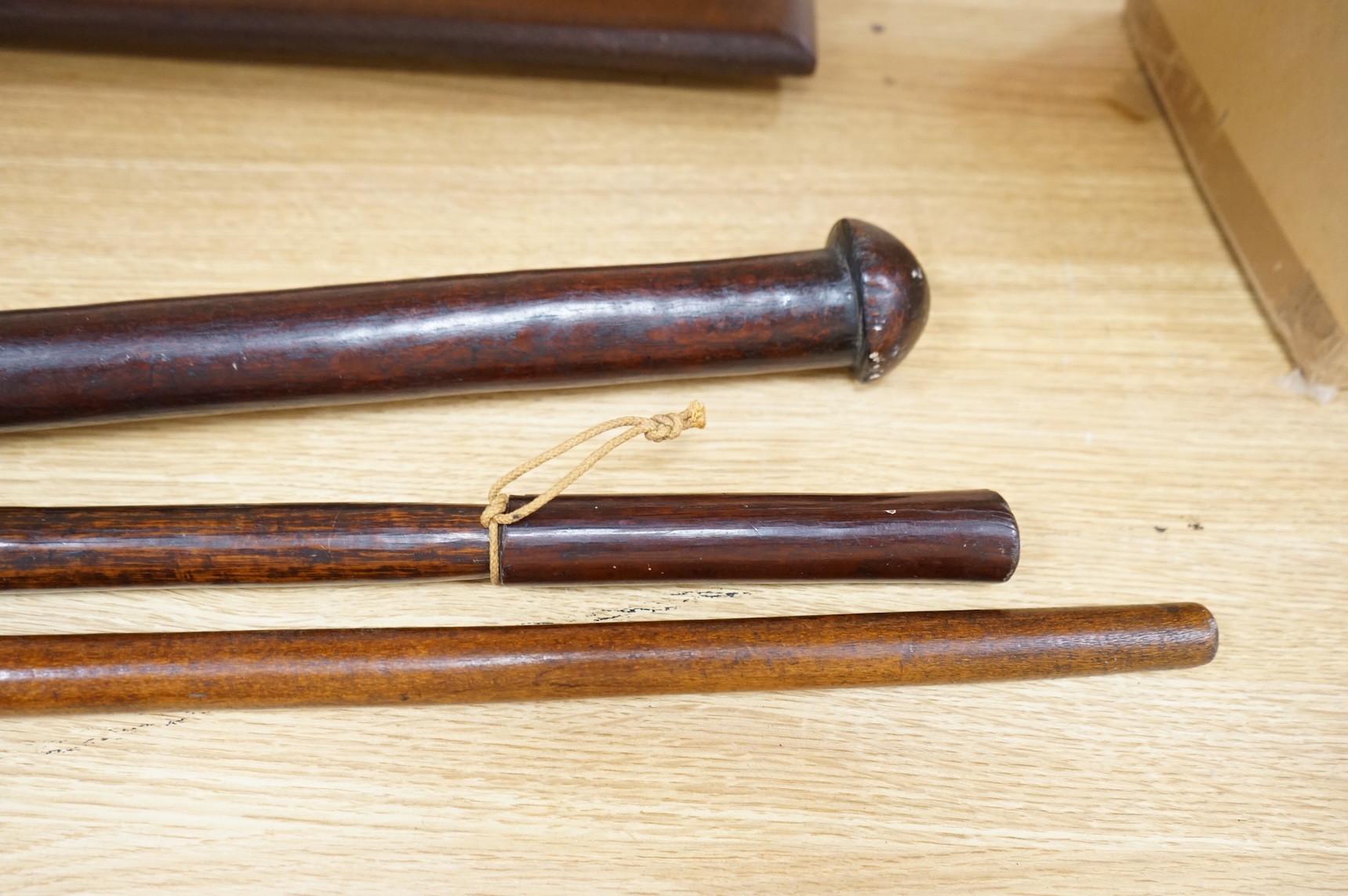 A Fiji hardwood club, probably 19th century or earlier, of gunstock form, overall length 89cm, together with a pole club, probably from Samoa, and a wooden walking stick (3)